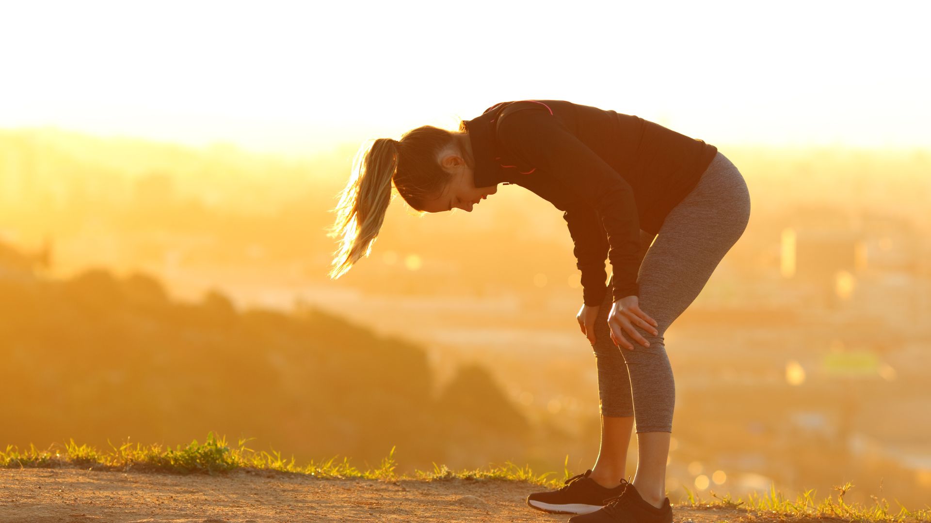 Exhausted female runner with hands on knees