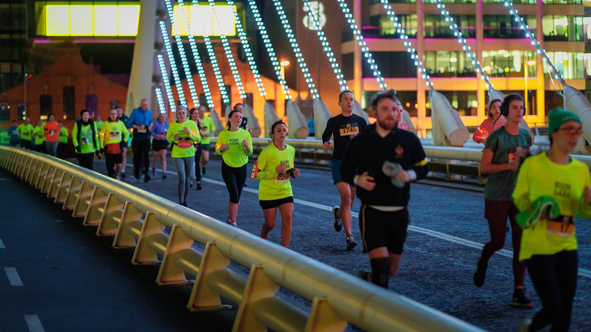 group of runners with high vis tops on bridge